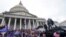 FILE - Rioters loyal to U.S. President Donald Trump swarm the U.S. Capitol in Washington, Jan. 6, 2021. Jason Donner, a former Fox News producer, says in a lawsuit that he was fired for pushing back against false claims about the riot.