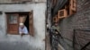 A Kashmiri woman looks on as a paramilitary soldier guard during the door-to -door election campaigning by Bharatiya Janata Party candidate ahead of the Jammu and Kashmir state assembly elections, in Srinagar, Indian controlled Kashmir, Aug. 29, 2024.