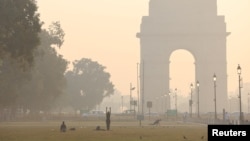 Orang-orang berolahraga di halaman rumput dekat Gerbang India di sepanjang 'Jalur Kartavya' pada pagi yang berkabut di New Delhi, India, 27 Oktober 2023. (Foto: REUTERS/Anushree Fadnavis)