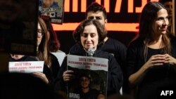 Former Russian-Israeli hostage Yelena Tropanov, center, holds a picture of her 27-year-old son Alexander (Sasha) Tropanov during a demonstration in Tel Aviv on Dec. 2, 2023, calling for the release of hostages held in Gaza since the October 7 attacks.