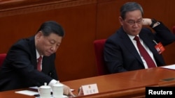 中國領導人習近平和中國總理李強在北京人大會堂出席全國人大會議閉幕式期間習近平在投票。 （2024年3月11日）
