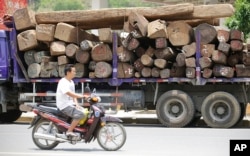FILE - In this May 25, 2012, photo, a truck transports logs with markings showing they came from across the border in Myanmar, in Ruili, Yunnan province, China.