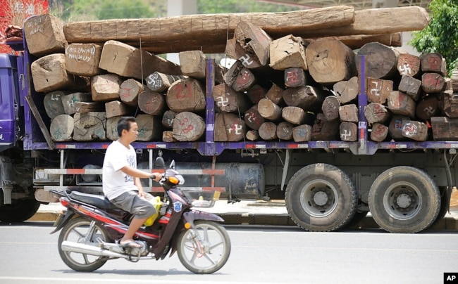 FILE - In this May 25, 2012, photo, a truck transports logs with markings showing they came from across the border in Myanmar, in Ruili, Yunnan province, China.