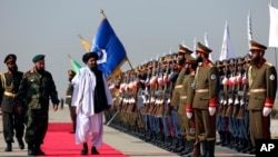 Mullah Abdul Ghani Baradar, the Taliban-appointed deputy prime minister for economic affairs, inspects the honor guards during a military parade, in Bagram Air Base, Aug. 14, 2024.