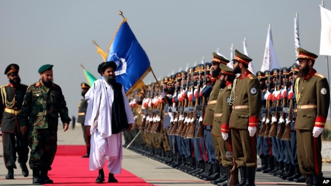 Mullah Abdul Ghani Baradar, the Taliban-appointed deputy prime minister for economic affairs, inspects the honor guards during a military parade, in Bagram Air Base, Aug. 14, 2024.