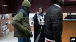 Samraa Luqman, co-chair of the Abandon Biden campaign in Michigan, hands out literature at the Islamic Center of Detroit, Jan. 26, 2024. Many Arab American leaders in the area are enraged about the administration's policy toward Israel's Gaza response.