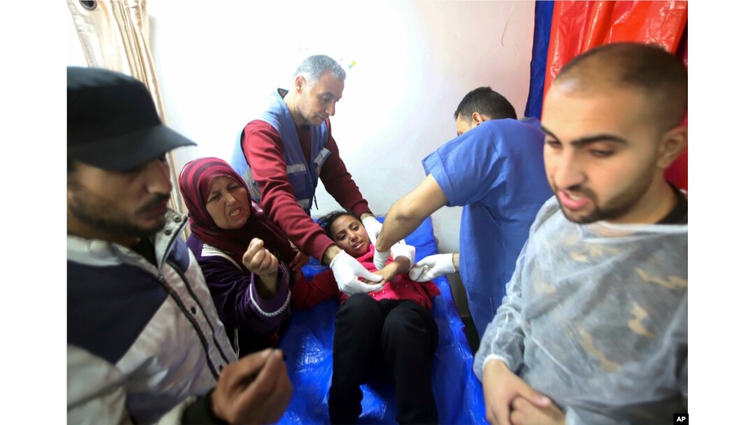 Petugas medis Palestina merawat seorang gadis yang terluka akibat serangan Israel di sebuah gedung UNRWA yang digunakan para pengungsi untuk berlindung di Khan Younis Kamis (24/1).