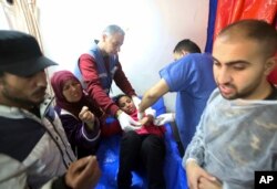 Petugas medis Palestina merawat seorang gadis yang terluka akibat serangan Israel di sebuah gedung UNRWA yang digunakan para pengungsi untuk berlindung di Khan Younis Kamis (24/1).