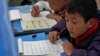 Siswa Tibet belajar tulisan Tibet di kelas satu di Sekolah Asrama Utama Shangri-La selama tur yang diselenggarakan untuk media di daerah Dabpa, Prefektur Kardze, provinsi Sichuan, China, 5 September 2023. (AP/Andy Wong)