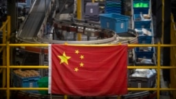 资料照片: 中国国旗悬挂在北京一个网上购物分拣处的货仓（2020年11月11日）