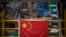 A Chinese flag hangs near an automated parcel handling line at a warehouse for an online retailer in Beijing, Nov. 11, 2020. (AP/Mark Schiefelbein)