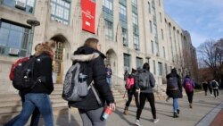 FILE - Students walk past an entrance to Boston University College of Arts and Sciences in Boston, Nov. 29, 2018. (AP Photo/Steven Senne, File)