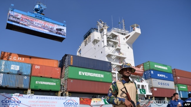 FILE - Pakistani Navy personnel stand guard near a ship carrying containers at the Gwadar port, some 700 kms west of Karachi, during the opening ceremony of a pilot trade programme between Pakistan and China, Nov. 13, 2016.