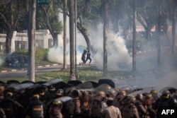 Para pengunjuk rasa berlari saat polisi menggunakan gas air mata selama demonstrasi menentang rencana pemerintah untuk mengembangkan Pulau Rempang menjadi zona ekonomi yang didanai China. (Foto: AFP)