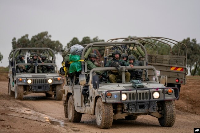 Israeli soldiers move near the border with the Gaza Strip, southern Israel, Monday, Nov. 27, 2023. (AP Photo/Ohad Zwigenberg)