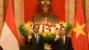 Presiden Joko Widodo (Kiri) dan Presiden Vietnam Vo Van Thuong (kanan) melambai saat pertemuan di Istana Kepresidenan di Hanoi pada 12 Januari 2024. (Foto: AFP/Nhac NGUYEN)