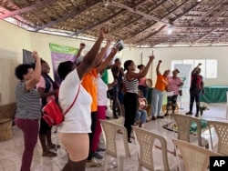 FILE - Members of the National Confederation of Rural Women sing during a visit from U.S. legislators and members of Women’s Equality Center at the organization’s headquarters in San Cristobal, Dominican Republic, Dec.8, 2023.