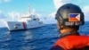 FILE - In this handout photo provided by the Philippine Coast Guard, members of the Philippine Coast Guard patrol at Whitsun Reef, South China Sea, April 14, 2021. 