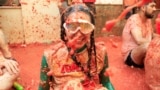 A participant covered in tomato pulp looks on, as people attend the annual food fight festival 'La Tomatina' in Bunol, near Valencia, Spain, Aug. 28, 2024.