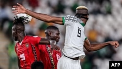 Avançado da Nigéria, Victor Osimhen, luta pela bola com o defesa da Guiné-Bissau Edgar durante o jogo de futebol do grupo A no CAN 2024. (Foto de FRANCK FIFE / AFP)