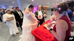 J.D. Walsh and Shalee Medina join around 700 other couples for a mass wedding at New York's Lincoln Center, July 8, 2023.