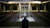 Royce Soble, of Atlanta, sits near a reflection pool at The Carter Center in Atlanta after the announcement that former first lady Rosalynn Carter had died, Sunday, Nov. 19, 2023. (AP Photo/Brynn Anderson)