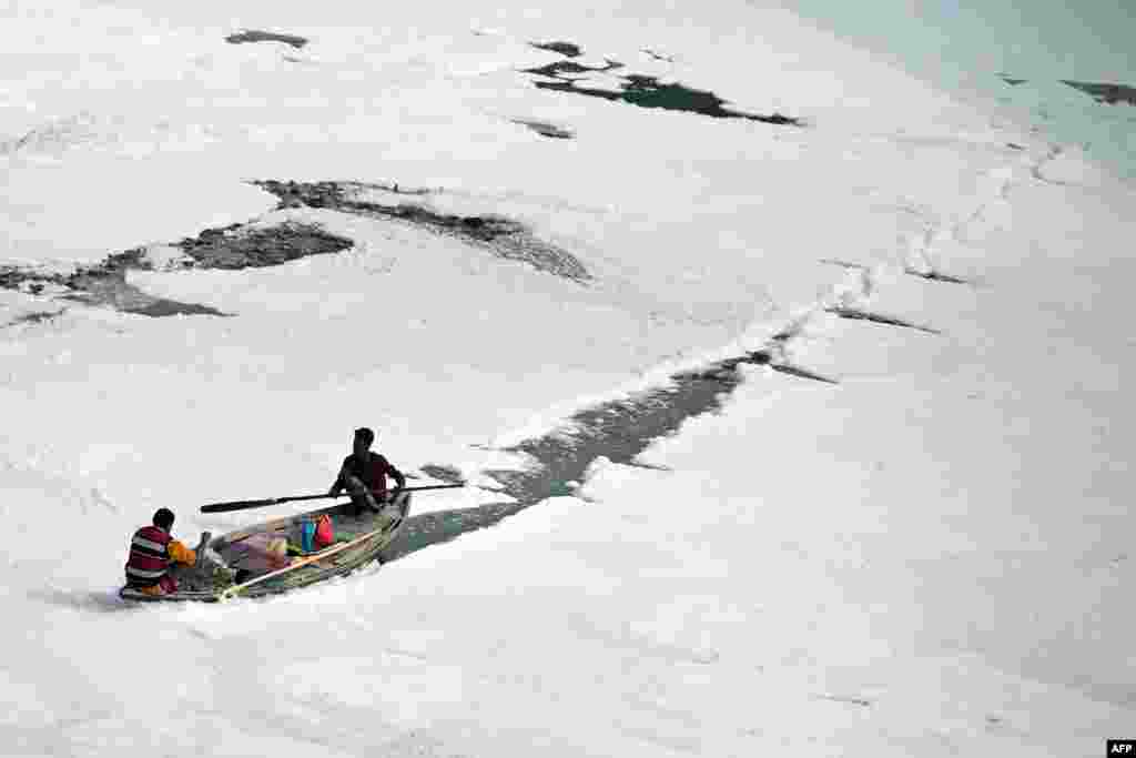 A boatman steers a boat in the polluted waters of the Yamuna River in New Delhi, India.