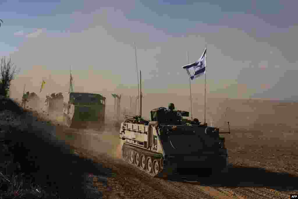 A convoy of Israeli military vehicles drives down a road at an undisclosed location on the border with the Gaza Strip.