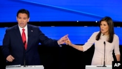 Former UN Ambassador Nikki Haley and Florida Gov. Ron DeSantis point at each other during the CNN Republican presidential debate at Drake University in Des Moines, Iowa, Jan. 10, 2024. 