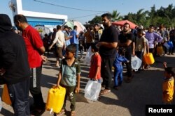 Palestinci, koji su pobegli iz svojih domova usled izraelskih udara, stoje u redu za vodu ispred šatora u kojima su pronašli sklonište u kampu Ujedinjenih nacija, nakon što je više od milion civila sa severa Gaze pobeglo na jug, u Kan Junisu, 26. oktobra 2023.