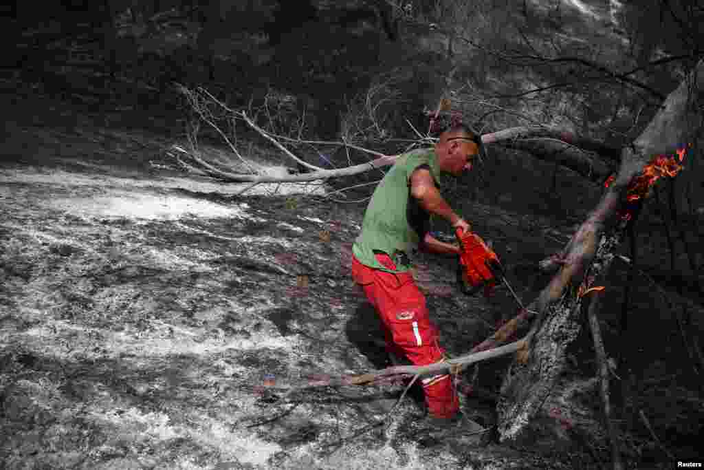 Military members of emergency services work to contain a wildfire near Cakran, Fier, Albania, July 26, 2023.