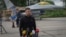 FILE - Ukraine's President Volodymyr Zelenskyy answers reporters' questions with a Ukrainian Air Force F-16 fighter jet in the background, in an undisclosed location in Ukraine, Aug. 4, 2024.