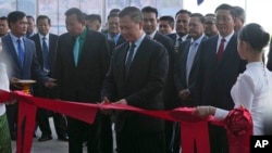 Cambodian Prime Minister Hun Manet, center, cuts the ribbon to inaugurate the Siem Reap-Angkor International Airport, in Cambodia, Thursday, Nov. 16, 2023.