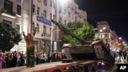 Members of the Wagner Group military company load their tank onto a truck on a street in Rostov-on-Don, Russia, June 24, 2023, prior to leaving an area at the headquarters of the Southern Military District.