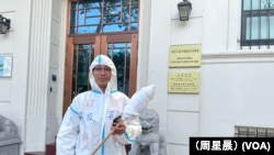 表演“大白”进行抗议的郑伟在中国驻旧金山总领事馆门前。（周星晨）