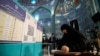FILE - A woman wears a hijab while filling out her ballot at a polling station in Tehran, Iran, March 1, 2024.