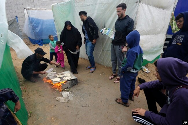 Palestinians displaced by the Israeli bombardment of the Gaza Strip cook near al Aqsa Hospital in Deir al Balah, Gaza Strip, Nov. 27, 2023.