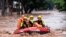 Rescue workers evacuate stranded residents on a flooded street after heavy rainfall in Wanzhou district of Chongqing, China, July 4, 2023. (China News Service photo via Reuters)