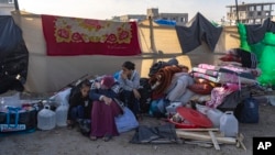 (FILE) Palestinians displaced by the Israeli bombardment of the Gaza Strip gather at a tent camp.