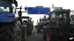 Farmers drive their tractors a highway leading to Paris's main airport, Jan. 29, 2024 near Chamant, north of Paris. 