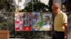 FILE - A man walks past electoral posters ahead of the July 23 snap election, in Ronda, Spain, July 7, 2023. 