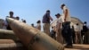 FILE - Activists stand near cluster bombs in Lebanon on Sept. 12, 2011. The United States provided cluster bombs to Kyiv in July 2023.