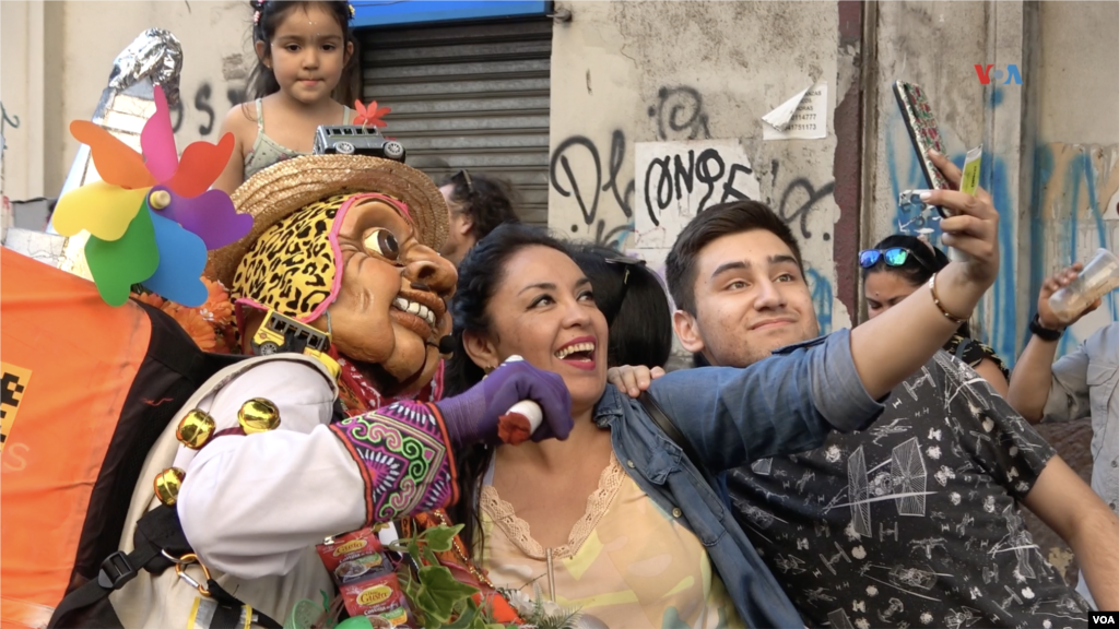 Familias chilenas se retratan con artistas de la compañía Pachakuna Guardianes de los Andes, que asiste al Festival Internacional Teatro a Mil, enero de 2024.