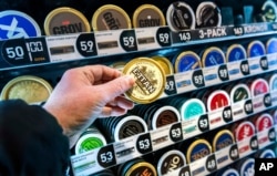 FILE - A man holds a box of snus (smokeless tobacco), at a store in Stockholm, on Jan. 23, 2023.