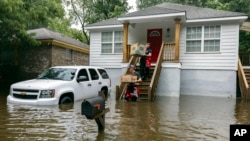 Savannah firefighters carry food to residents in the Tremont Park neighborhood that were stranded in stormwater from Tropical Storm Debby, Aug. 6, 2024, in Savannah, Ga.