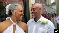 Hazel Seivwright-Carney and her husband, Rohan Carney, smile at one another at New York's Lincoln Center, July 8, 2023. 