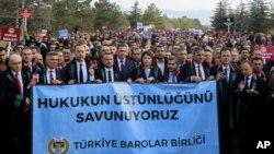 People, mostly lawyers, hold a banner that reads in Turkish, "We defend the supremacy of law," during a protest called by the Union of Turkish Bar Associations, in Ankara, Nov. 10, 2023.