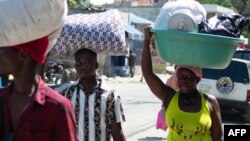 Watu wanaoishi karibu na gereza wakiwa wamebeba mizigo yao waliondoka katika jiji la Port-au-Prince, Haiti, March 4, 2024.Picha na AFP 