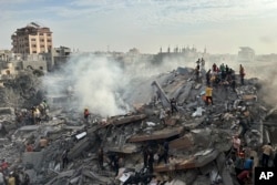 FILE - Palestinians look for survivors following Israeli airstrike in Nusseirat refugee camp, Gaza Strip, Oct. 31, 2023.