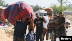 Displaced Palestinians make their way as they flee Hamad City following an Israeli evacuation order, amid Israel-Hamas conflict, in Khan Younis in the southern Gaza Strip, Aug. 11, 2024.